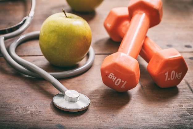 Green apple dumbbells and stethoscope