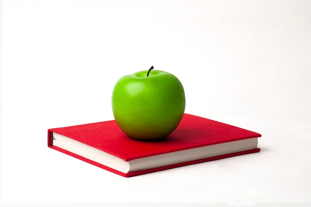 a green apple on a new book