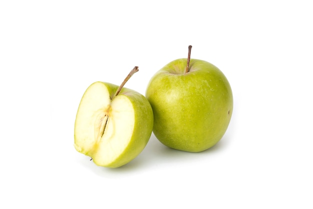 Green apples on a white background. Ripe green apples on an isolated background. Green apples with green leaves on an isolated background. A group of green apples from whole apples sliced slices.