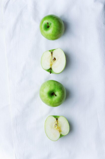 Green apples over white cloth above view