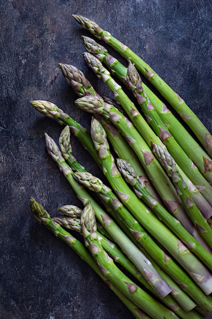 Green asparagus on a dark background. Raw food concept. The vegetable is rich in fiber