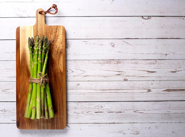 Green asparagus on wooden board Top view flat lay Copy space