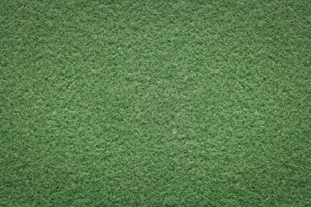 Green background of softness felted wool Textured fluffy wool fabric Warm fabric with short pile for outerwear Closeup top view