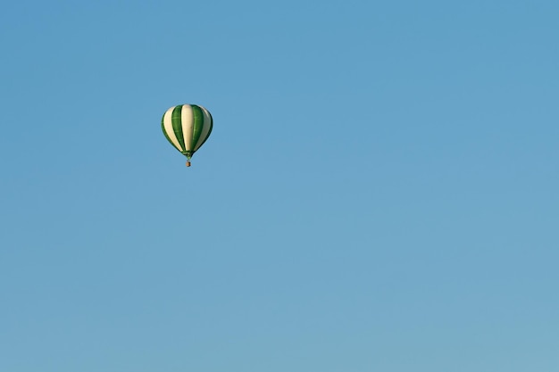 A green balloon in a clear blue sky