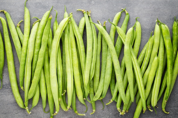 Green beans  on a gray surface.