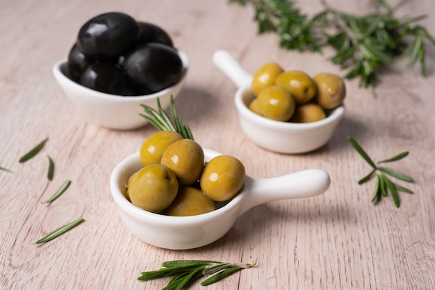 green and black olives on the table with rosemary