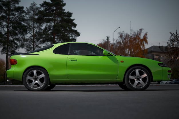 Green and black sport coupe car with big wheels. Japanese oldtimer.