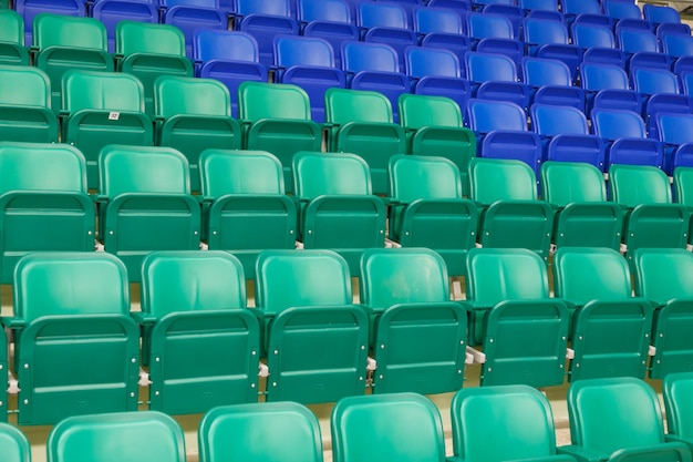 Green and blue plastic spectator stadium seats Nobody empty rows