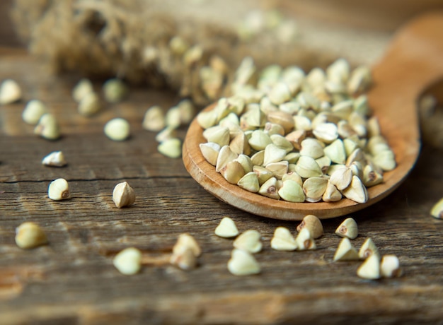 Green buckwheat close-up in a wooden bowl on an old wooden table. healthy food