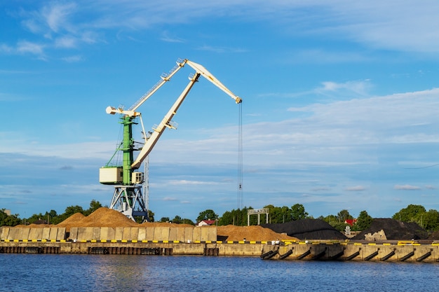 Green cargo crane in terminal in river ship port in Ventspils, Latvia, Baltic sea. Shipping import