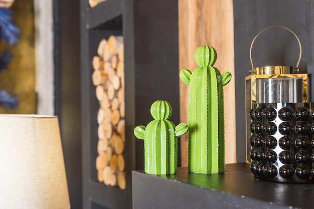 Green ceramic figure of a cactuses Decorative toy sculpture on black shelf Stylish decor for home interiorModern and floral concept of home