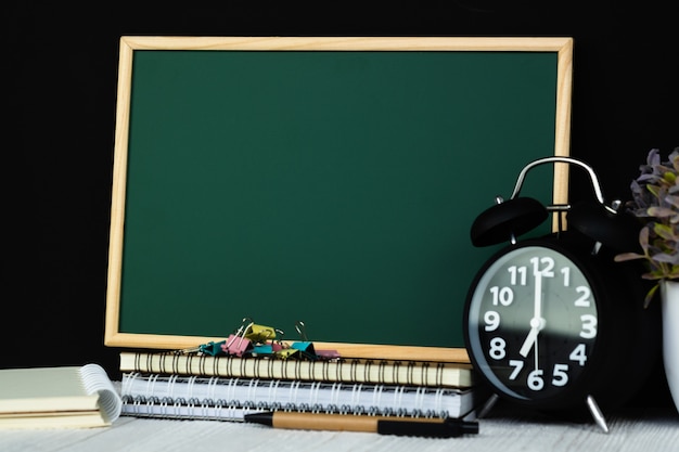 Green chalkboard with pile of notebook paper