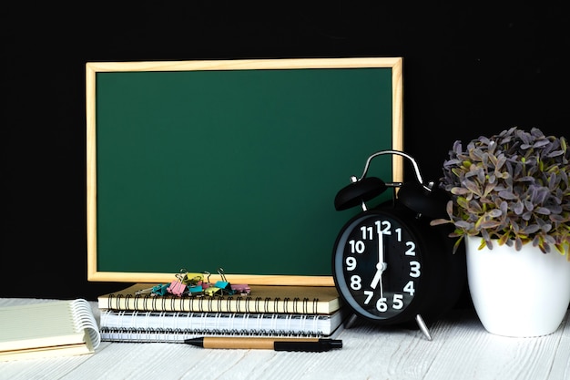 green chalkboard with pile of notebook paper