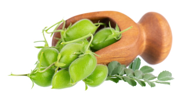 Green chickpeas in wooden spoon isolated on white background Chickpeas in the pod with green leaves Cicer arietinum Clipping path