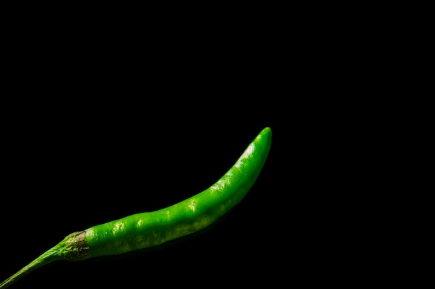 Green chili hot and fresh isolated on black background studio photography