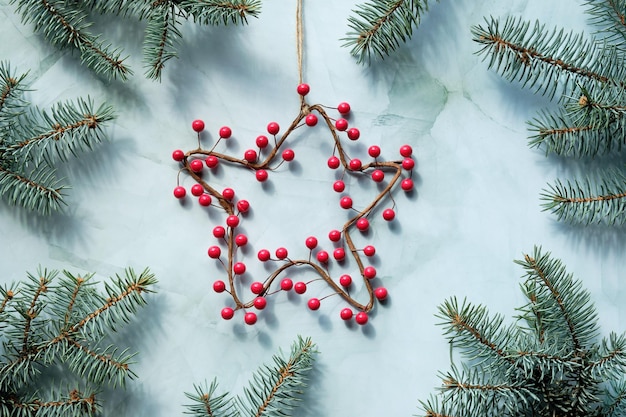 Green Christmas backdrop with Xmas wreath in star shape Green flat lay with undecorated fir twigs on stone