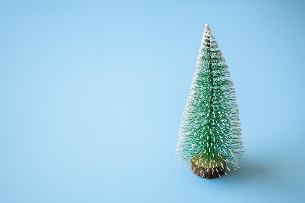 Green Christmas tree on blue pastel background new year holiday celebration concept