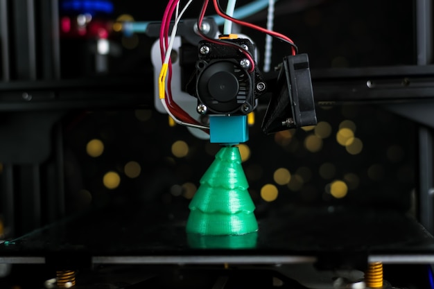 Green Christmas tree printed on 3D printer. technology.