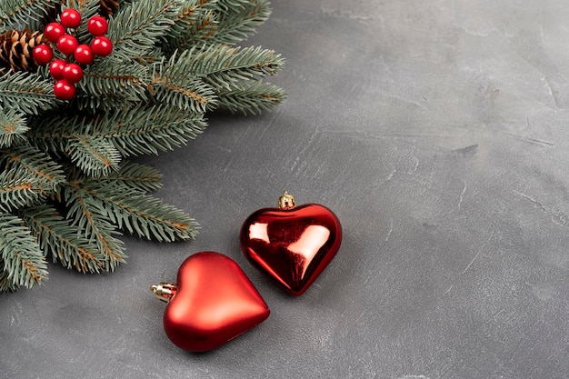 Green Christmas wreath with decorations of two heart shape bubble on a gray background Top view