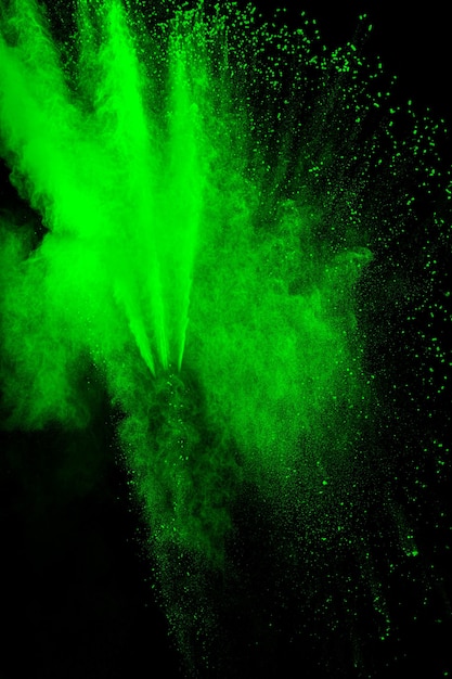 Green color powder explosion cloud  on black background.Green dust splash on background.