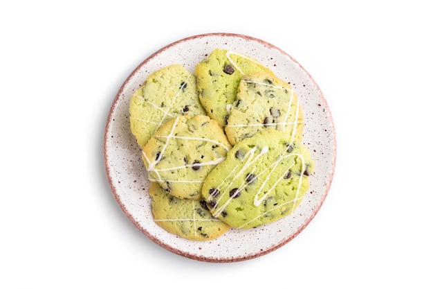 Green cookies with chocolate and mint on ceramic plate isolated on white background top view close up