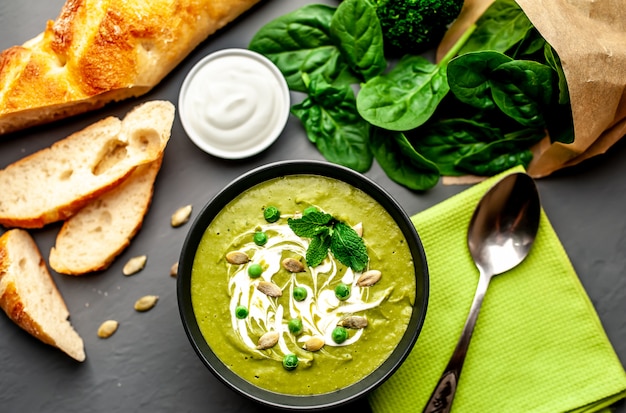 Green cream soup of spinach and broccoli. concrete or slate background. The concept of a healthy diet and diet.