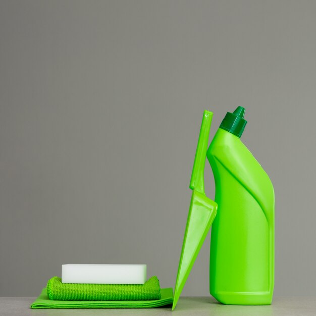 Green detergent bottle for toilet, sponge, scoop and dust cloth. Cleaning tools.