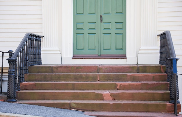 A green door with a black door on the left side