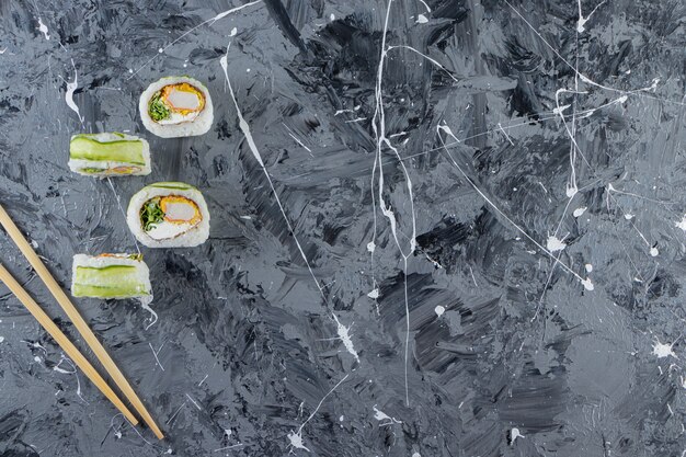 Green dragon sushi rolls placed on marble background. 