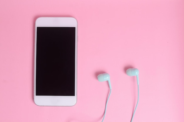 Green earphones for use with digital music or smartphones on a bright pink background