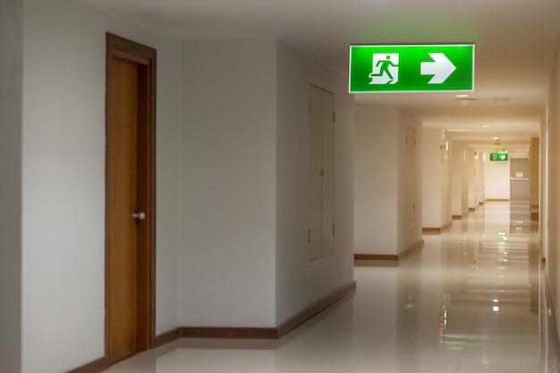 Green emergency exit sign in hotel showing the way to escape