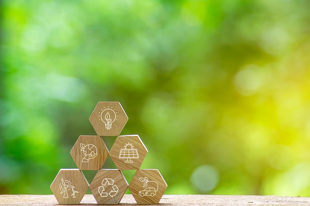 Green energy concept Wooden block on desk with green energy icon on virtual screen