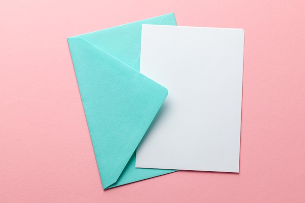 Green envelope and blank letter on pink background Template with place for text on postcard