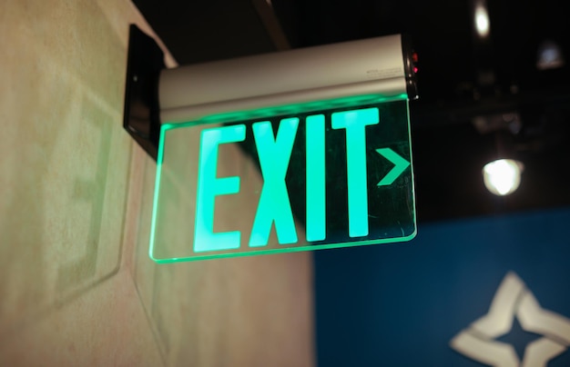 A green exit sign hanging from a wall