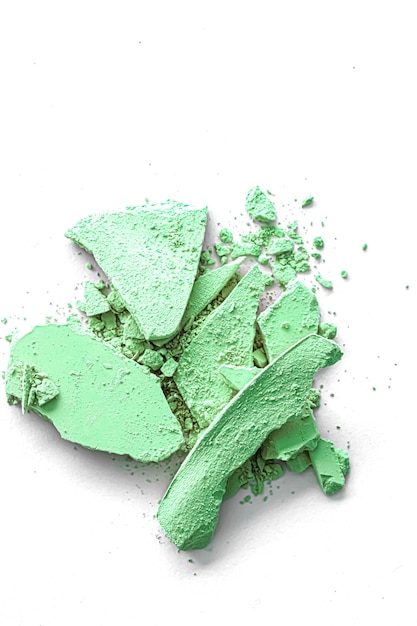 Green eye shadow powder as makeup palette closeup isolated on white background crushed cosmetics and beauty texture