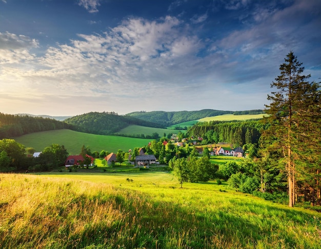 Photo a green field with a house in the background and a house in the middle of the valley