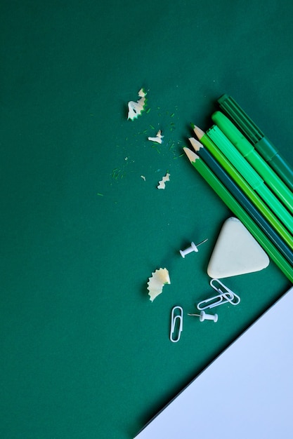 Green Flat lay Back to school concept, School and office supplies on with copy space. Lots of different stationery items on colorful background