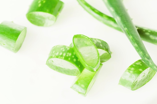 Green fresh aloe vera leaves and slices on white background Top view Flat lay