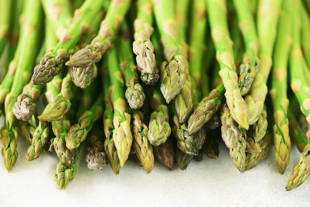 Green fresh asparagus on gray background. Top view. Raw, vegan, vegetarian and clean eating concept.