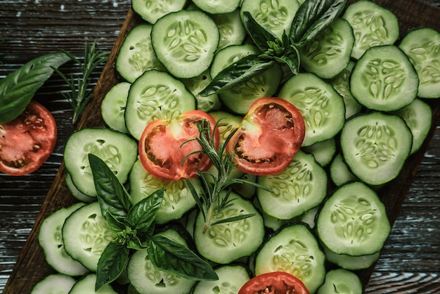 Green fresh farm edible sliced cucumbers tomatoes with basil and rosemary herbs 1