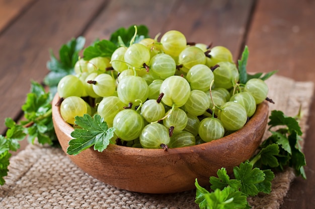 Green gooseberries in a wooden bowl