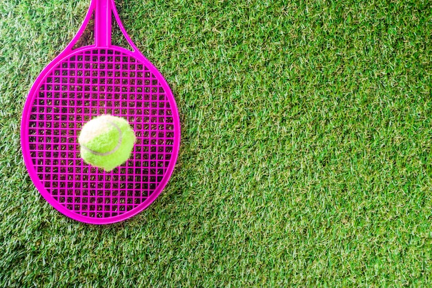 green grass with tennis racket and ball.