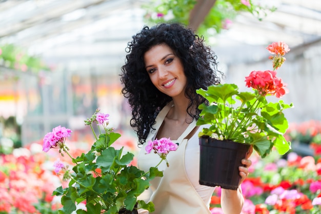 Green house female employee showing you some flowers