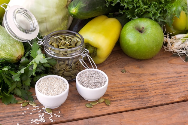 Green hypoallergenic vegetables in wooden box and the seeds. Vegetarian food. Selective focus, top view.