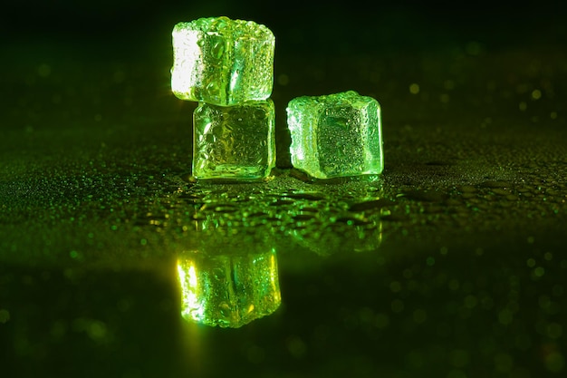 Green ice cubes on black background