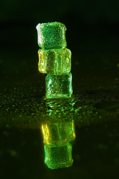 Green ice cubes on black background