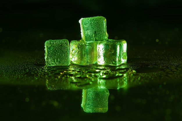 Green ice cubes on black background