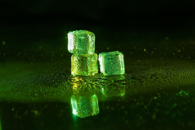 Green ice cubes on black background