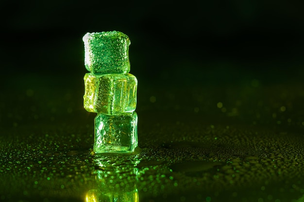 Green ice cubes on black background