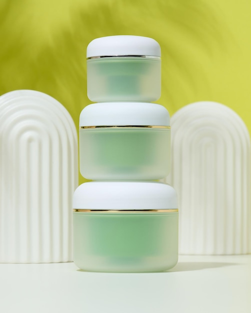 Green jar for cosmetics on a white table Packaging for cream gel serum